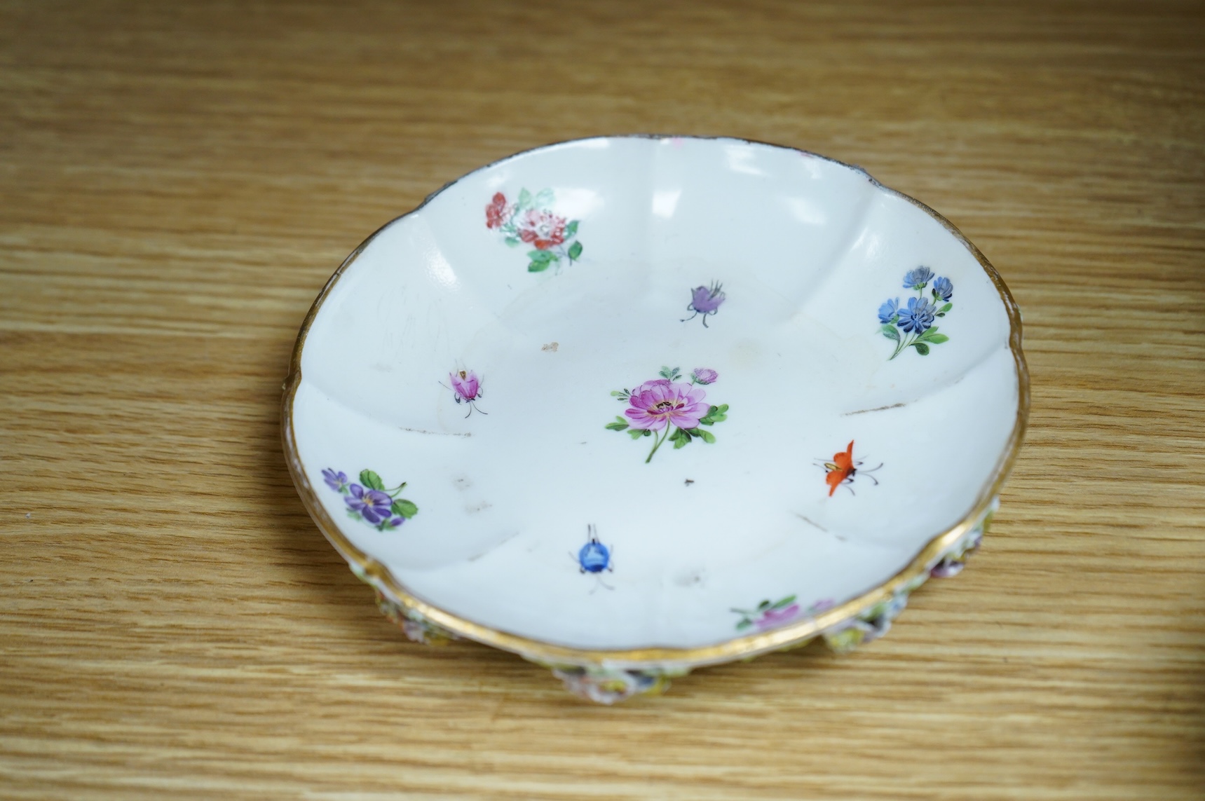 A 19th century Meissen floral encrusted cup and saucer, 14cm diameter